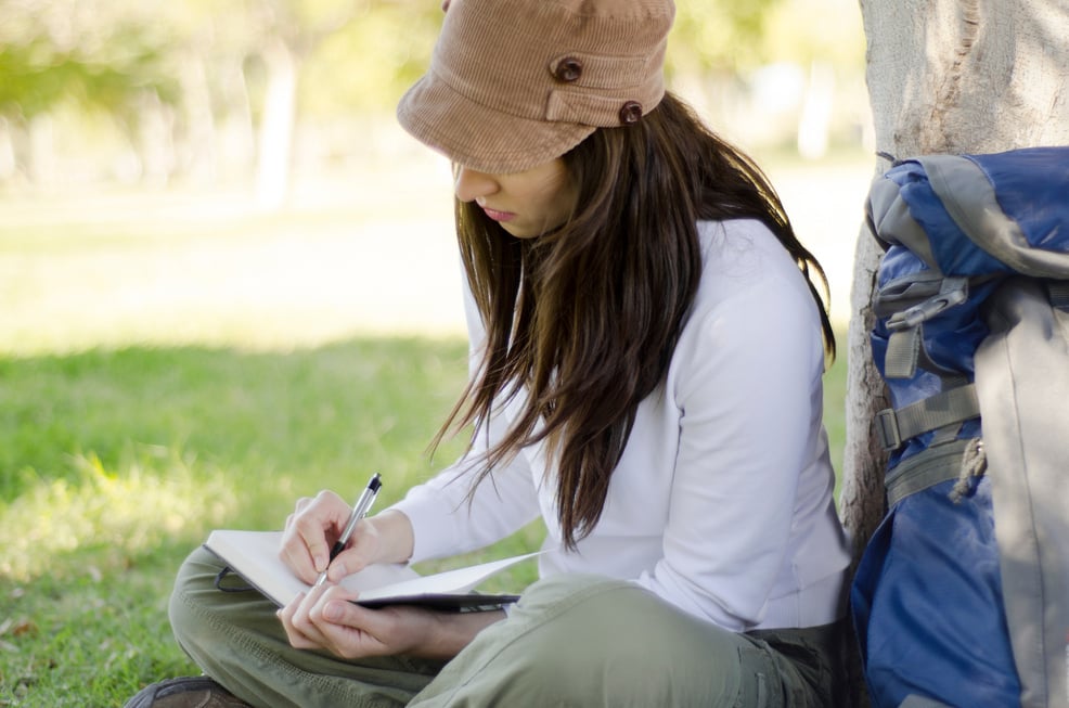 Woman writing on travel journal